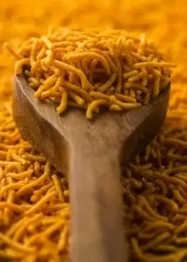 Aloo Bhujiya: A spoon of Indian dish made with crispy potato strands, spices, and herbs.